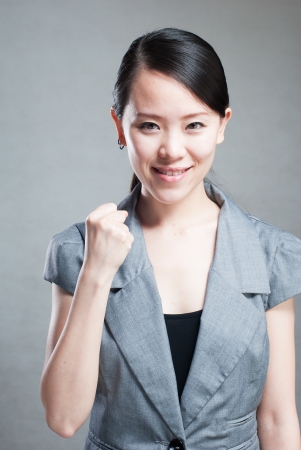 Happy Asian woman with her arms in the air cheeringの写真素材