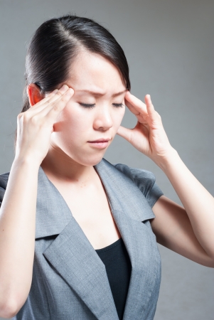 Young woman with head pain on white backgroundの写真素材