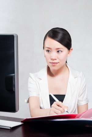 Young pretty business woman with notebook in the officeの写真素材