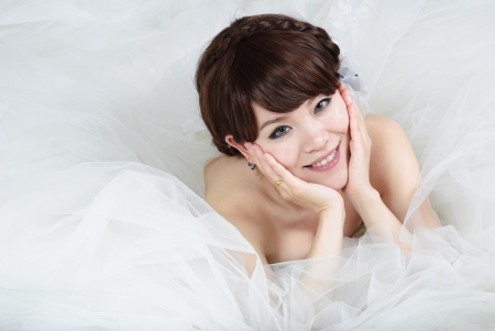 bride sitting in wedding dress, studio shotの写真素材