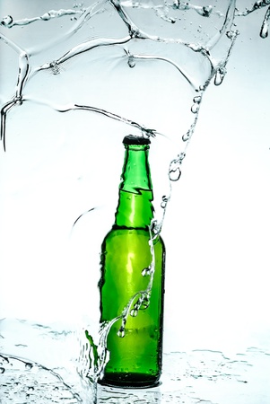Beer bottle with water splashの写真素材