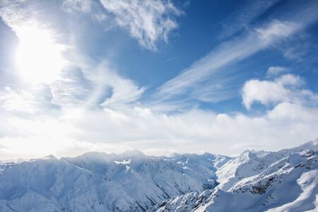 Alpine sky with clouds over the top of mountains