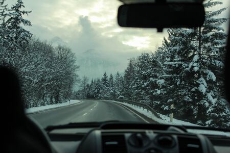 Road trip in the car driving through snowy mountains in Tirol, Austriaの写真素材