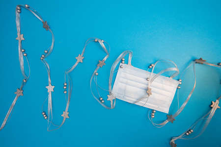 Medical mask wrapped with Christmas decorative silver ribbon with starsの写真素材