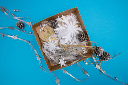 Box with Christmas decorations laying on blue backgroundの写真素材