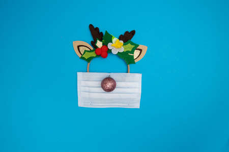 Medical mask with deer Christmas band and decorated with Christmas ballの写真素材