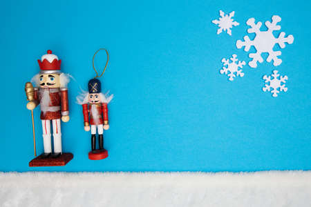 Nutcrackers on blue background with white snowflakes and white fur as snowの写真素材
