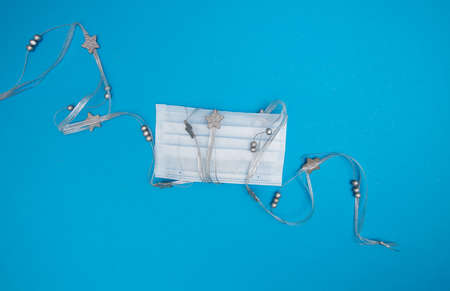 Medical mask wrapped with Christmas decorative silver ribbon with starsの写真素材
