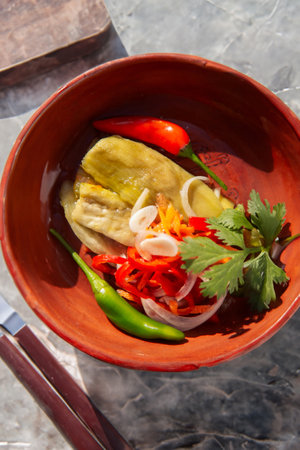 Roasted peppers, beautifully presented in a rustic clay bowl, bursting with smoky flavor and vibrant colors.の写真素材