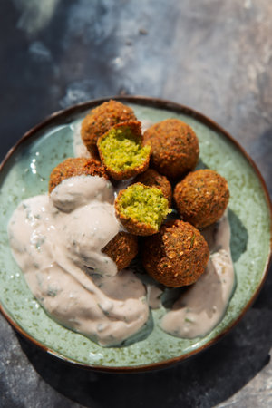 Delicious falafel topped with creamy white sauce, a flavorful and satisfying Middle Eastern street food.の写真素材
