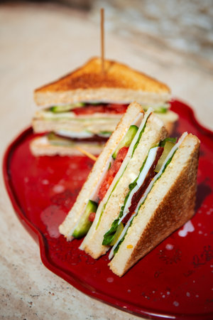 Delicious club sandwich, perfectly sliced, revealing its mouthwatering layers of ingredients.の写真素材