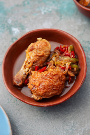 A succulent chicken leg beautifully presented on a rustic clay plateの写真素材