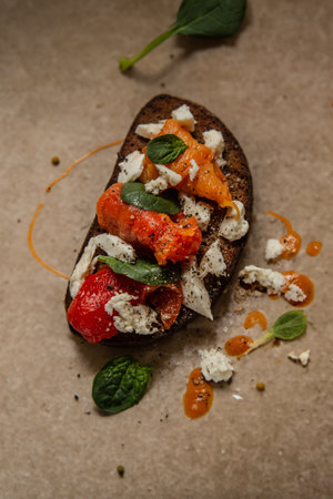 bruschetta with herbs, cheese and roasted peppers on a board