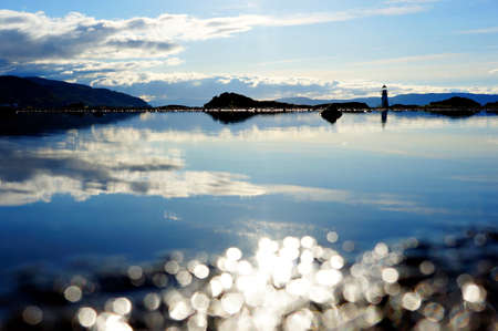 Reflection of the sky in the water. Landscape with a lighthouse