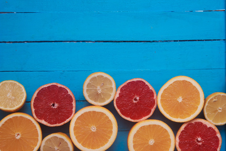 Fresh citrus fruits with green leaves on wooden blue backgroundの写真素材