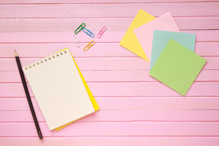 Top view of blank notebook page on pastel colored background office desk with different objects. Minimal flat lay style.の写真素材