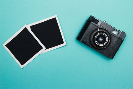 vintage retro camera on wooden table background with blanks photo to placed your pictures, bouquet of pink roses, gift boxes and heart made from film. valentines day background. top viewの写真素材