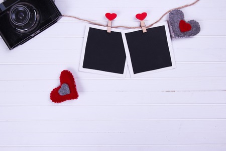 vintage retro camera with blank photo frames and pink roses flower bouquet with red ribbon and gift boxes. top view. valentines day backgroundの写真素材