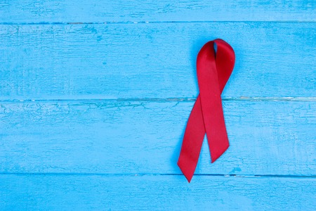 Red ribbon HIV, AIDS on blue background