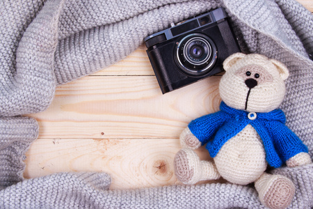 knitting teddy bear with vintage camera on a wooden backgroundの写真素材