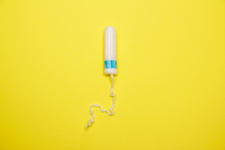 Womans hygiene and health. White tampon on background. Cotton tampon. Womens comfort, hygiene and protection.の写真素材