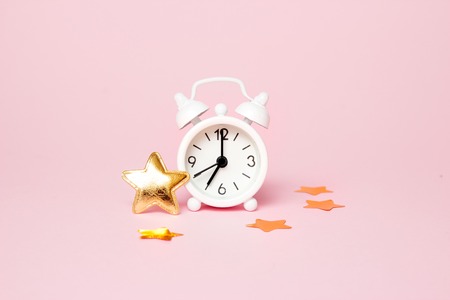 Retro alarm clock with party decoration on pink background. Copy space.の写真素材