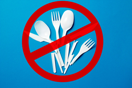 White single-use plastic knives, spoons, forks on a blue background. Say no to single use plastic. Environmental, pollution conceptの写真素材