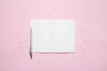 Top view of open empty notebook with star confetti on pastel pink colorful background.の写真素材