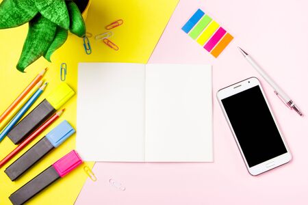 Front view colour pencils smartphone notepads on yellow background. Empty text important future events. What to do home school office.の写真素材