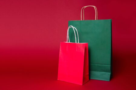 Two christmas red and green shopping paper bag on red background. Mock upの写真素材