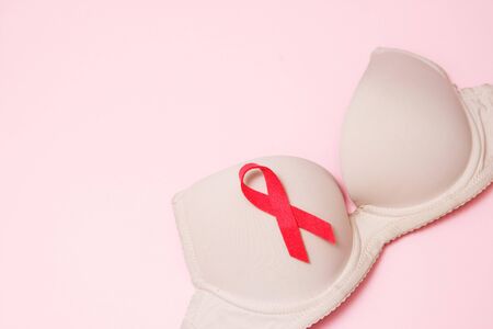 Bra with a symbol of the month of breast cancer awareness on a pink background top view, flat lay. Women's Health Conceptの写真素材