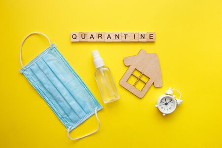 Top view of green background with virus outbreak word on protective medical masks and a thermometer....