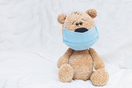 Cute teddy bear with face mask on his mouth on white backgroundの写真素材