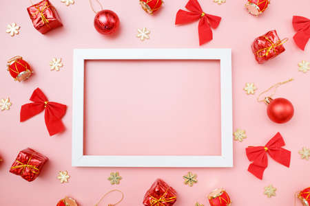 Christmas greating card composition. Christmas red and golden decorations with frame on pink background. Flat lay, top view, copy space.の写真素材