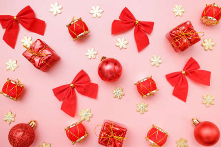 Christmas greating card composition. Christmas red and golden decorations with on pink background. Flat lay, top viewの写真素材