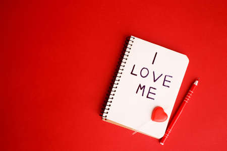 A notebook with a written phrase I love myself on red background. Concept mental health journaling, healthy mindset, accepting myself.の写真素材