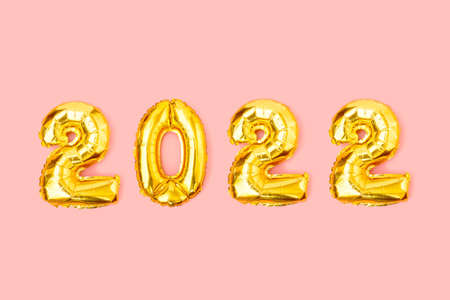 Foil balloons in form of numbers 2022. Happy New Year celebration concept. Gold balloons isolated on pink background. Flat lay, top viewの写真素材