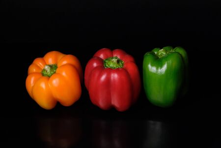 red yellow green pepper on a black backgroundの写真素材