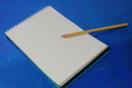 notepad pencil on blue backgroundの写真素材