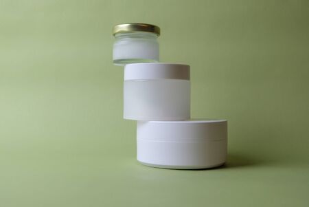 jars with cosmetics on a green backgroundの写真素材