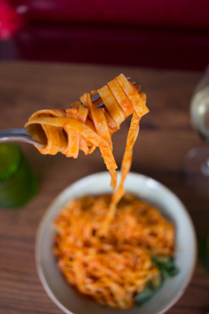 Pasta Marinara topped with fresh basil on a wood backgroundの写真素材