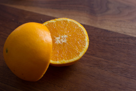 Sliced Orange on a walnut wood backgroundの写真素材
