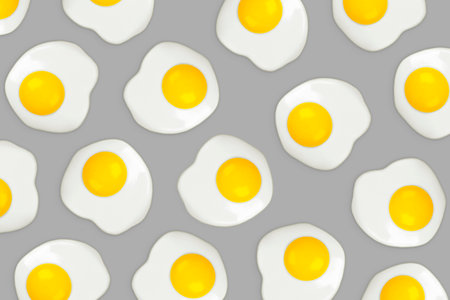 Fried eggs on a gray background pattern. Colors of the year 2021 - Illuminating and Ultimate Gray. Flat lay, top viewの写真素材