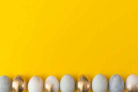 Golden and gray eggs on a yellow background. Minimal easter conceptÐ¼Ð¡Ð¡の写真素材