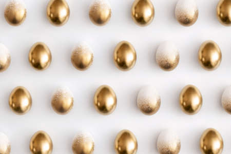 Pattern composition of golden eggs on a white background. Minimal easter concept.の写真素材