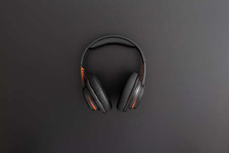 Headphones on black leather background. Music concept. Flat lay composition. Top view.の写真素材