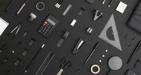 Pattern composition of office and school stationery on black leather background. Back to school