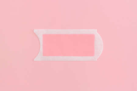 Pink waxing strips on pink background. Top view with copy space. Flat lay composition.の写真素材