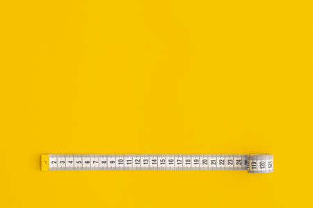 Measuring tape on yellow backgroundの写真素材