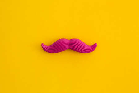 Pink mustache on yellow background. Top view with copy space. Flat lay.の写真素材